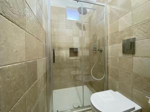 e bagno con doccia, servizi igienici e lavandino. di Uria Rooms & Suite B&B a Vieste