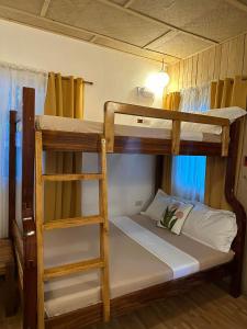 a bedroom with two bunk beds with a ladder at Cabin D at Bigang Munti in Batangas City