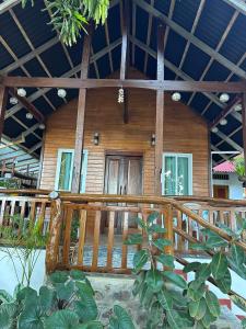 a wooden house with a wooden railing in front of it at Cabin D at Bigang Munti in Batangas City
