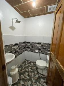 a bathroom with a toilet and a sink at Cabin D at Bigang Munti in Batangas City
