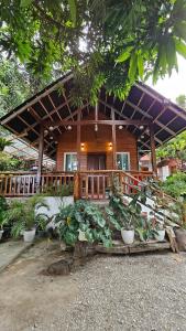 una casa de madera con plantas delante de ella en Cabin D at Bigang Munti en Batangas