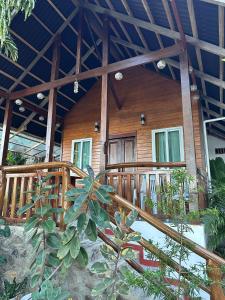 a house with a wooden deck and a porch at Cabin D at Bigang Munti in Batangas City