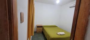 チレシトにあるDepartamento Villa Auroritaの小さなベッドルーム(緑のベッド1台、ナイトスタンド付)