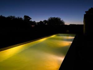 a swimming pool with lights on top of it at Le Mas de Bonnety - Magnifique mas 12 personnes au Pied du Mont Ventoux in Saint-Pierre-de-Vassols