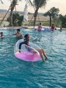 a group of people swimming in a swimming pool at KHÁCH SẠN AQUARIUSGARDEN VÂN LONG NINH BÌNH in Ninh Binh