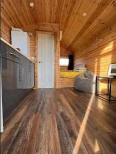 Großes Zimmer mit einem Bett in einer Holzhütte in der Unterkunft The Red Kite - 2 person Pet Friendly Glamping Cabin in Dungarvan