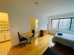 Habitación con mesa, cama, mesa y sillas. en Stylish Montreal Apartment: Comfortable Stay in the Golden Square Mile, en Montreal