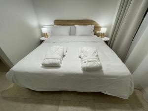 ein Bett mit weißen Handtüchern darüber in der Unterkunft TEGEA LUXURY SUITES Artemis in Tripolis