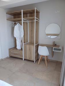 a dressing room with a wooden cabinet and a white chair at TEGEA LUXURY SUITES Artemis in Tripolis