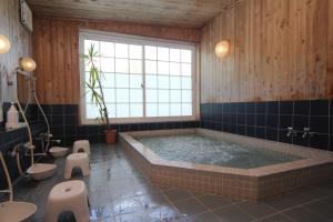 a large bathroom with a large tub and toilets at Lodge Clubman in Hachimantai +30 photos