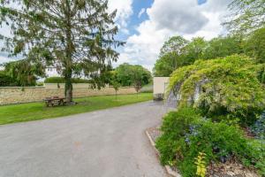 une allée dans un parc avec un banc et des arbres dans l'établissement Gîte Rilly-la-Montagne, à Rilly-la-Montagne