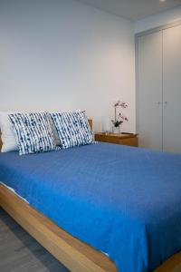 a bedroom with a large bed with a blue blanket at Alojamento Moinho d`Óbidos in Óbidos