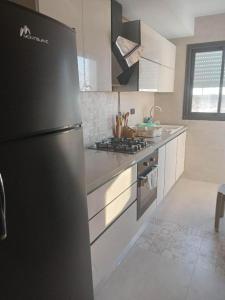 a kitchen with a black refrigerator and a stove at Tunisia la goulette in La Goulette