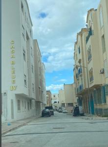 an empty street in a city with buildings and cars at Tunisia la goulette in La Goulette