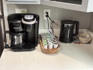 a counter with a coffee maker and some cupcakes at Spacious Retreat Near Convention Centers home in Des Plaines