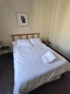 a large bed with white sheets and pillows at B Appartement in Malakoff