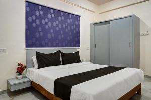 a bedroom with a large bed with a large wall at Super OYO Esta Inn in Pune