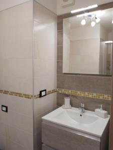 ein Bad mit einem Waschbecken und einem Spiegel in der Unterkunft bbcascata in Bocenago