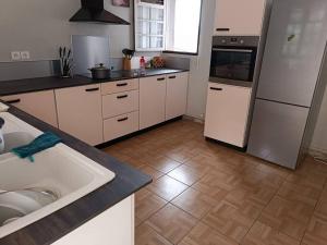 a kitchen with a sink and a stove and refrigerator at Maison de 4 chambres avec jacuzzi terrasse et wifi a Riviere Pilote a 3 km de la plage in Rivière-Pilote