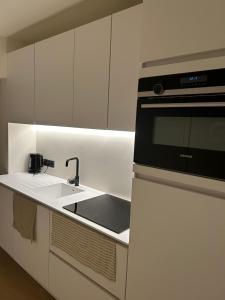 a kitchen with a sink and a microwave at Louis-Gabriël in De Panne