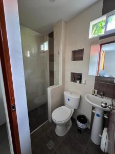 uma casa de banho com um WC, um chuveiro e um lavatório. em Montes De Beraka em Minca