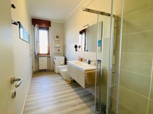 a bathroom with a shower and a sink and a toilet at Elegante Appartamento Tre Amis - Doppio Garage & Free WiFi - AC in Centallo +16 photos
