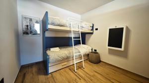 a bedroom with a bunk bed with a ladder at Hostdomus - Oslo Apartments in Borgata Sestriere