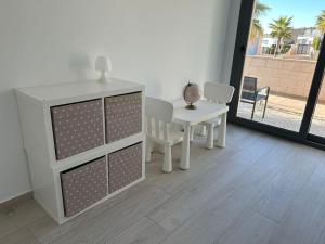 a white dresser and a table and a table and chair at Villa Tropical - Alegría Village in Finestrat