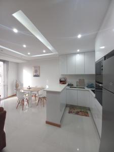 a kitchen with white cabinets and a table in it at SuAparts in Praia