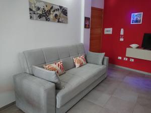 sala de estar con sofá gris con almohadas en Casa Vacanze di Alex en Càbras