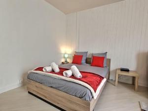 een slaapkamer met een groot bed met rode kussens bij L'Escapade Perchée*Disney*Paris* in Pomponne