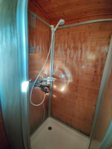 a shower with a hose attached to a wooden wall at Kivakko Saariselän paratiisi - Oma ranta & sauna in Saariselka