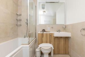 a bathroom with a toilet and a sink and a tub at The Clapham Terraced House in London