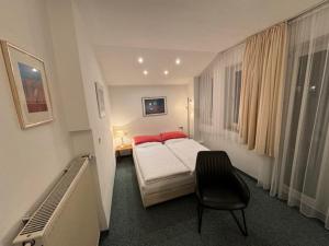 1 dormitorio con 1 cama y 1 silla en Hotel Occam en Múnich