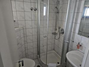 a bathroom with a shower with a toilet and a sink at Hotel Tennenloher Hof in Erlangen
