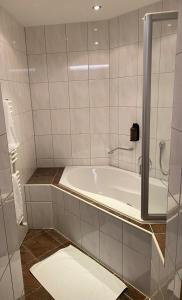 a bath tub in a bathroom with a shower at Hotel Tirol in Ischgl