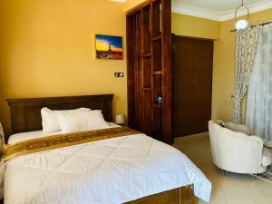 1 dormitorio con 1 cama y 1 silla en Casa Mia BnB, en Kampala
