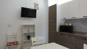 kuchnia ze stołem i krzesłami oraz telewizor na ścianie w obiekcie Stella di Mare w mieście Balestrate