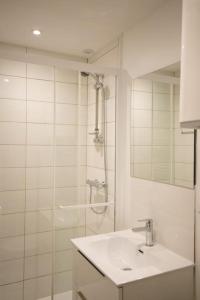 y baño blanco con lavabo y ducha. en Studio paisible, parking gratuit, emplacement vélo, en Auxerre
