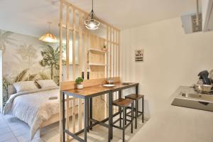 een slaapkamer met een bed, een tafel en een wastafel bij Studio paisible, parking gratuit, emplacement vélo in Auxerre