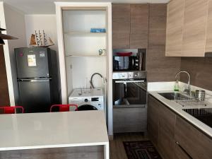 a small kitchen with a refrigerator and a stove at Arriendo departamento excelente ubicación por día in Viña del Mar