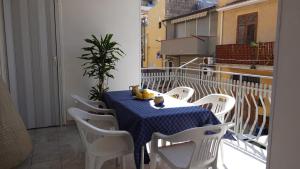 einen blauen Tisch und weiße Stühle auf dem Balkon in der Unterkunft Stella di Mare in Balestrate