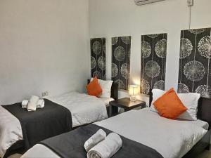 a room with two beds with orange and white pillows at Pensiunea La Bozi in Utvin