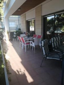 een patio met stoelen en een tafel op een veranda bij Andros Residence in Limassol