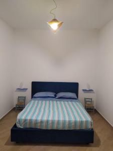 a bed with a blue headboard in a room with two tables at Casa vacanze Maison Zio Bruno A' Scalinatella in Naples