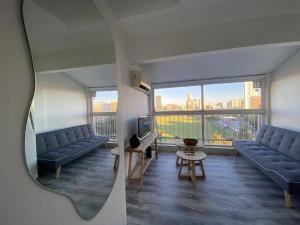 een woonkamer met twee blauwe banken en een tafel bij Departamento en Cañitas Campo de Polo in Buenos Aires