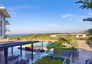 a view of a resort with a swimming pool and the ocean at 1 bedroom apartment in Sibaya in Sibaya