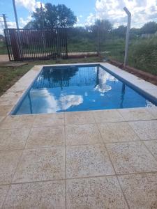 una pequeña piscina con agua azul en un patio en Hermosa Casita paso patria III en Paso de la Patria