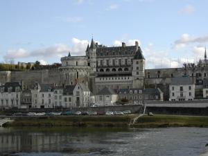 a large castle sitting on the side of a river at Villa Le Clos de Mosny in Amboise