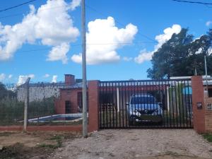 a gate with a car parked behind it at Hermosa Casita paso patria III in Paso de la Patria